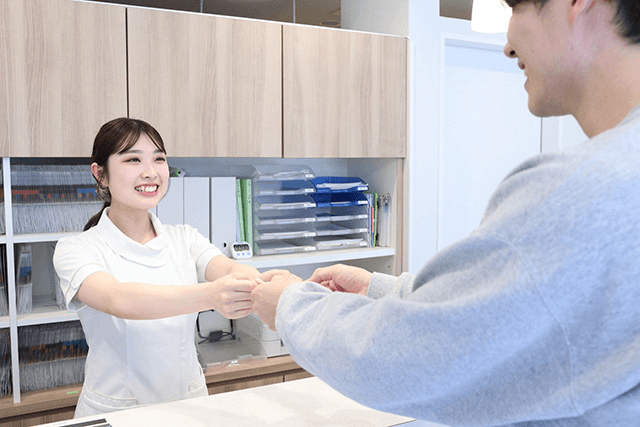 受付で問診票を記入する様子