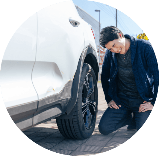 車のそばで困っている男性